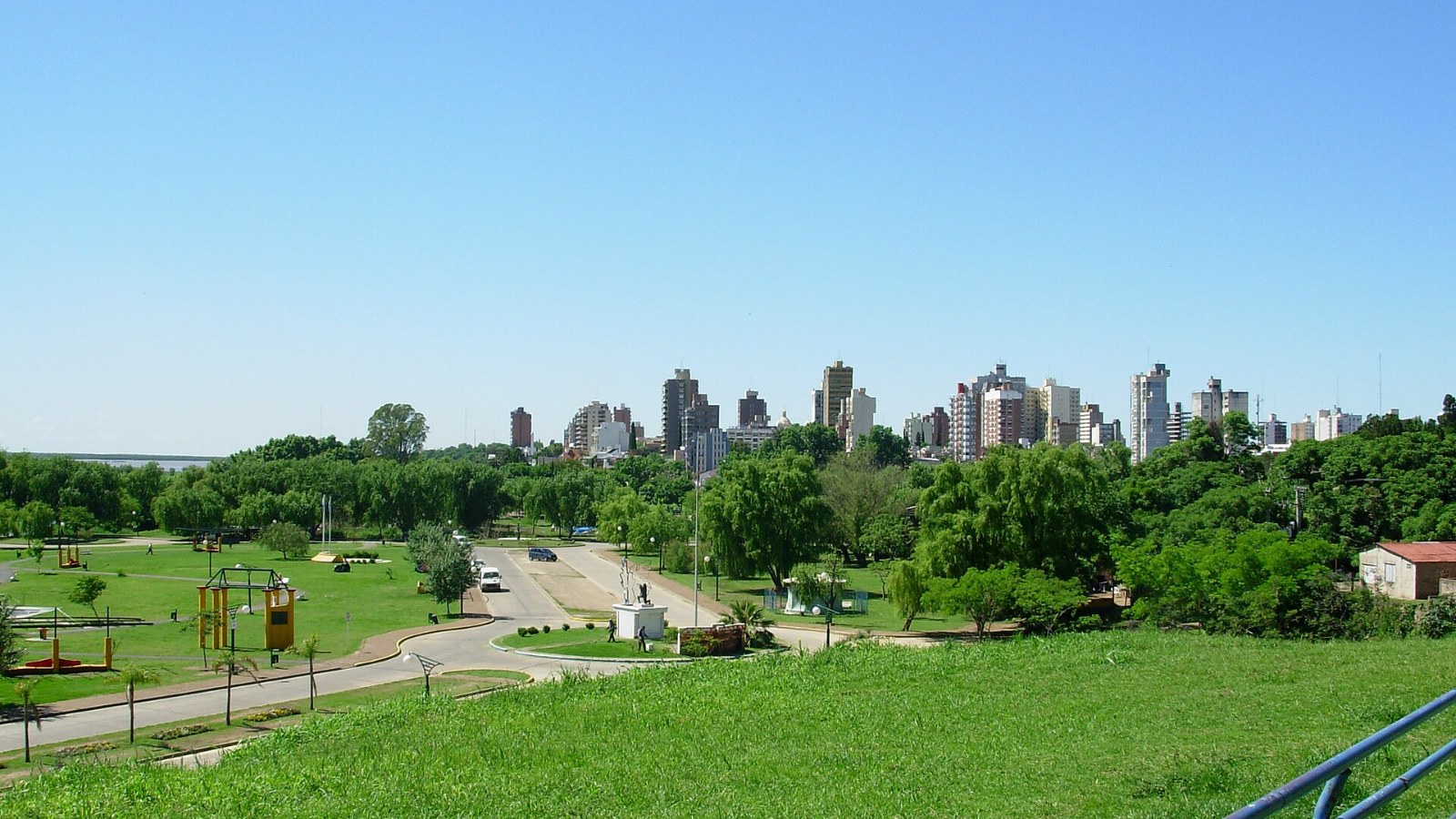 Vista de Rosario desde el Campito de la costanera, con cielo despejado y pasto verde
