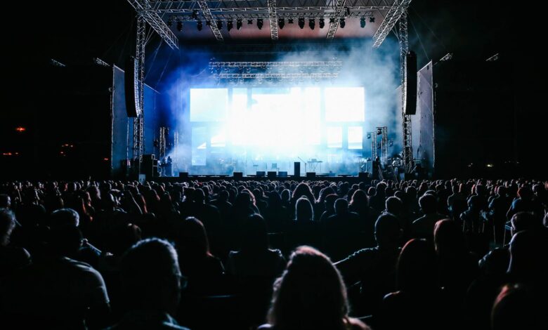 Público frente a un escenario iluminado durante un recital