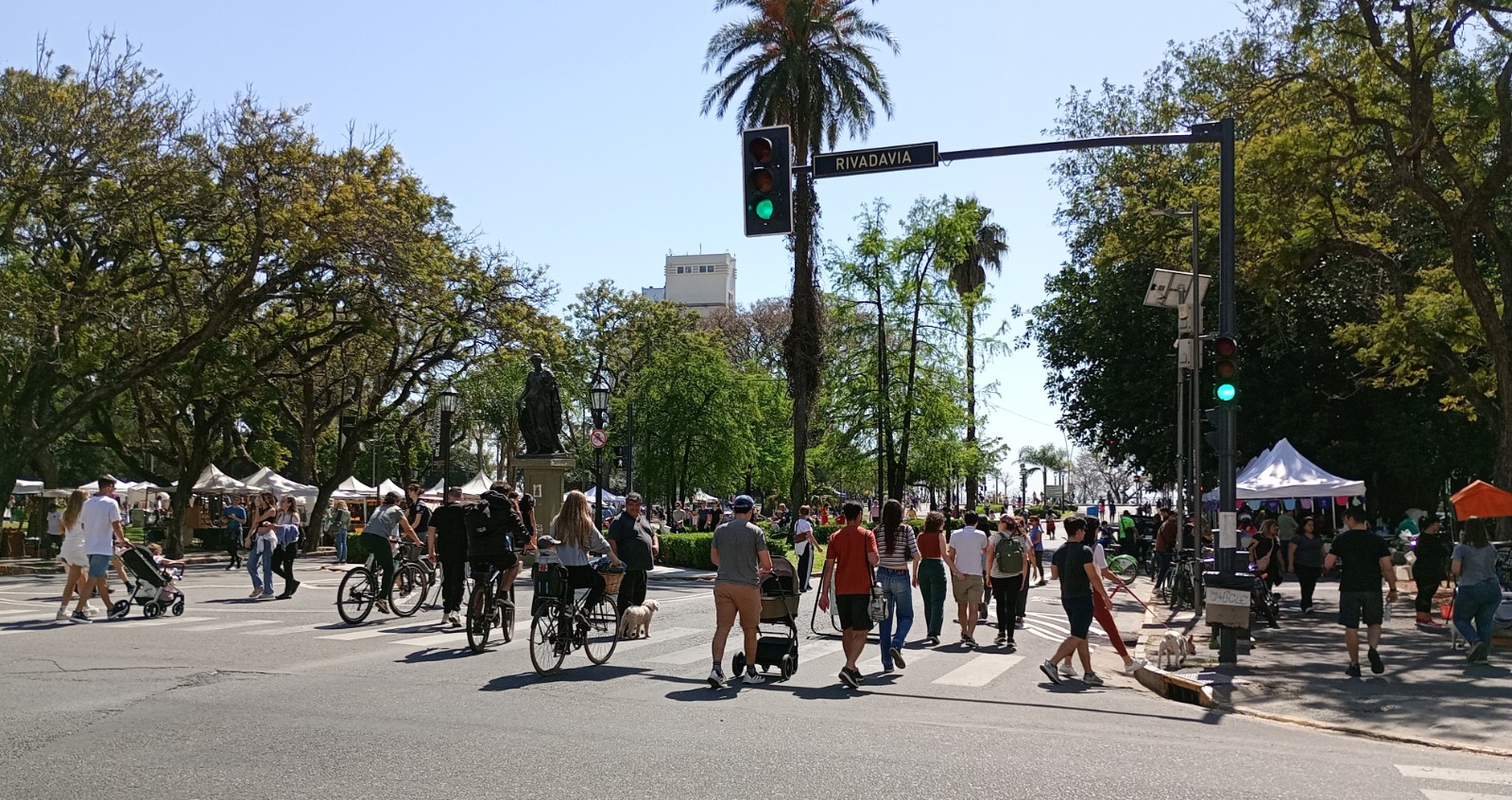 Ciclistas y caminantes en bulevar Oroño y Rivadavia, cerca del río, durante una mañana de domingo