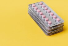 Blísters de pastillas apilados sobre un fondo amarillo