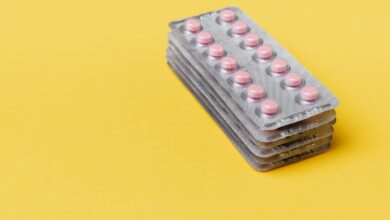 Blísters de pastillas apilados sobre un fondo amarillo