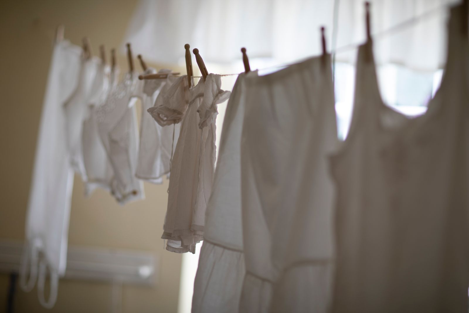 Ropa blanca colgada en perchas y tendedero