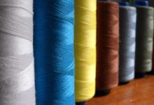 Carreteles de hilo de coser de distintos colores alineados