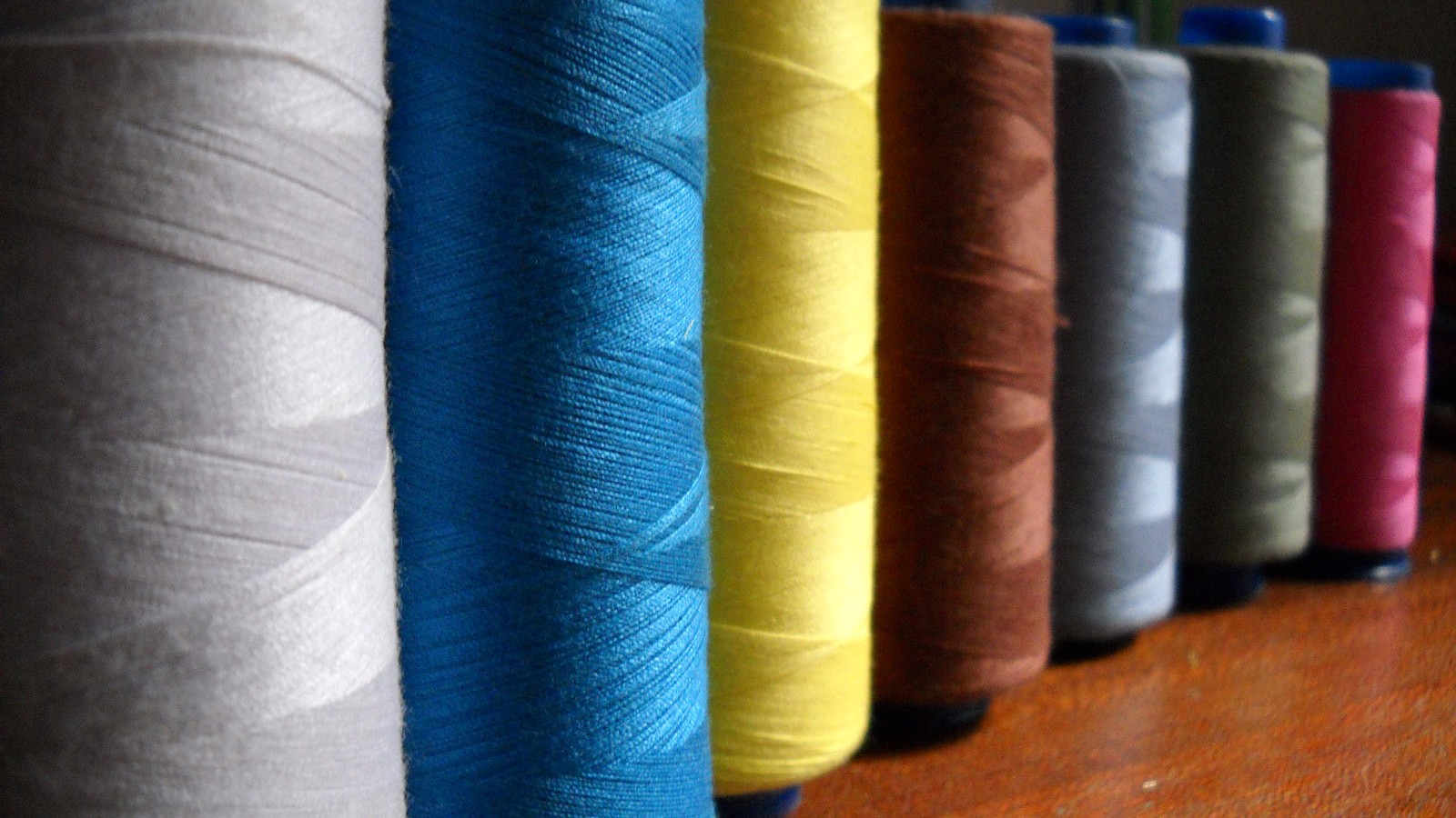 Carreteles de hilo de coser de distintos colores alineados