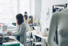 Emprendedora cose en una máquina en su taller de diseño de indumentaria