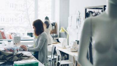Emprendedora cose en una máquina en su taller de diseño de indumentaria