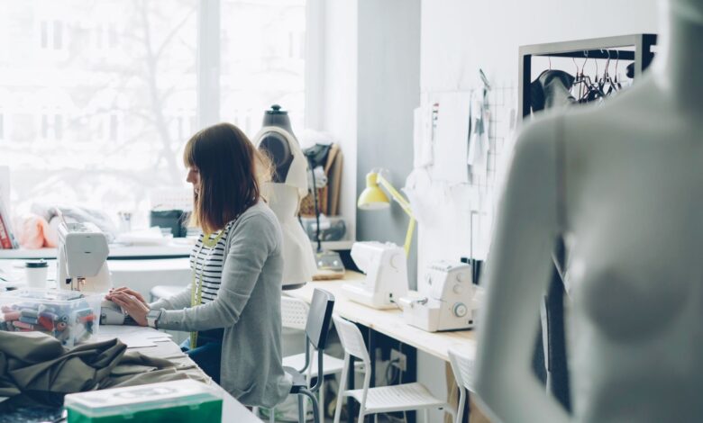 Emprendedora cose en una máquina en su taller de diseño de indumentaria