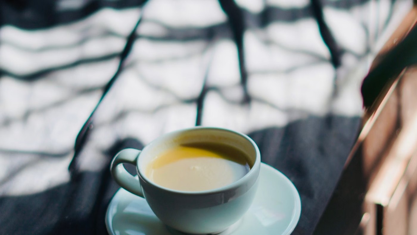 Taza de té sobre un platito con la luz de la mañana