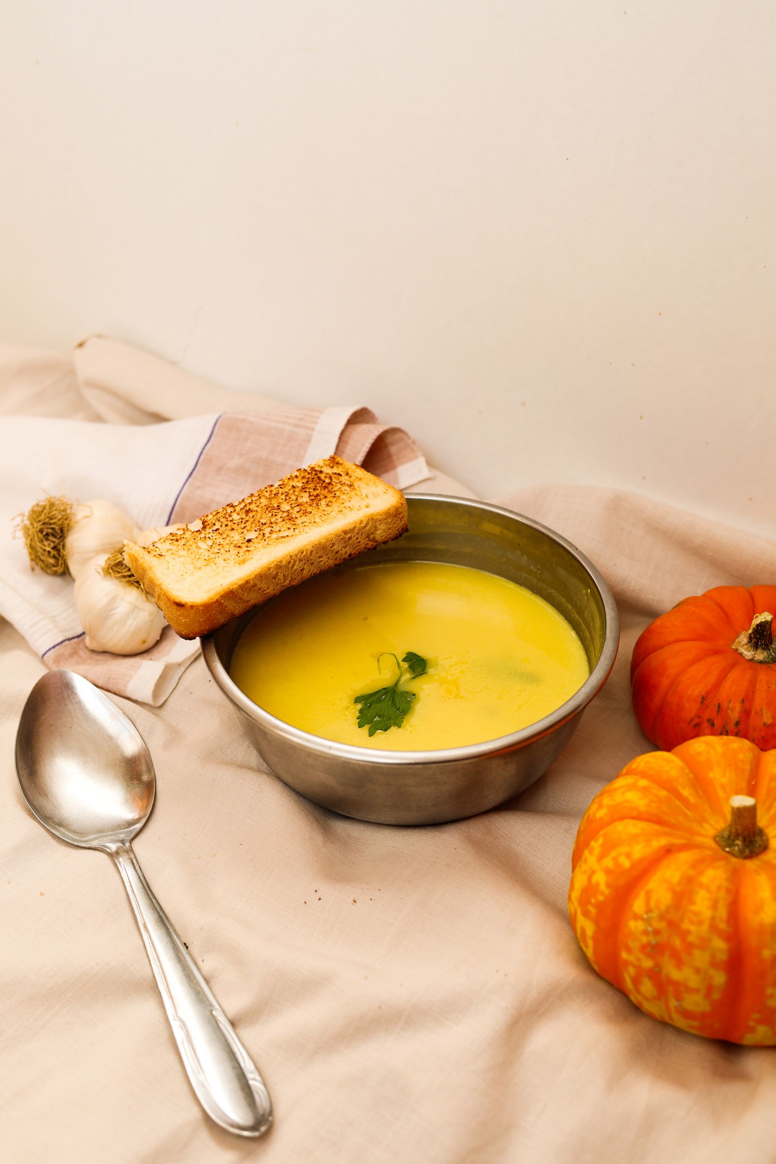 Sopa crema de calabaza servida en un bowl junto a calabazas