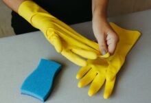 Guantes de goma amarillos y esponja para tareas de limpieza en una casa