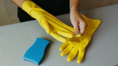 Guantes de goma amarillos y esponja para tareas de limpieza en una casa
