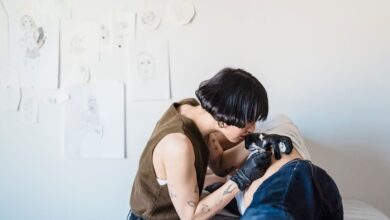 Tatuadora trabaja concentrada en un estudio de tatuajes