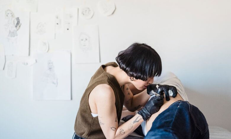 Tatuadora trabaja concentrada en un estudio de tatuajes