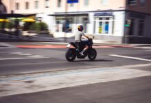 Motociclista circulando por una avenida urbana a plena luz del día