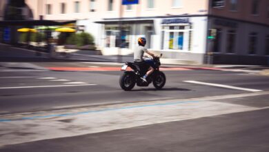 Motociclista circulando por una avenida urbana a plena luz del día