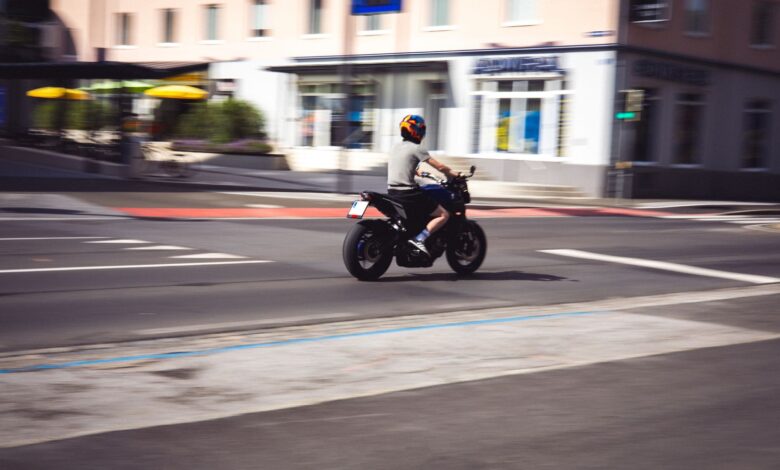 Motociclista circulando por una avenida urbana a plena luz del día