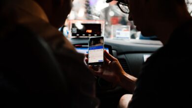 Dos personas usan el celular para guiarse dentro de un auto de noche