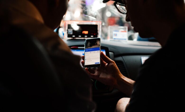 Dos personas usan el celular para guiarse dentro de un auto de noche