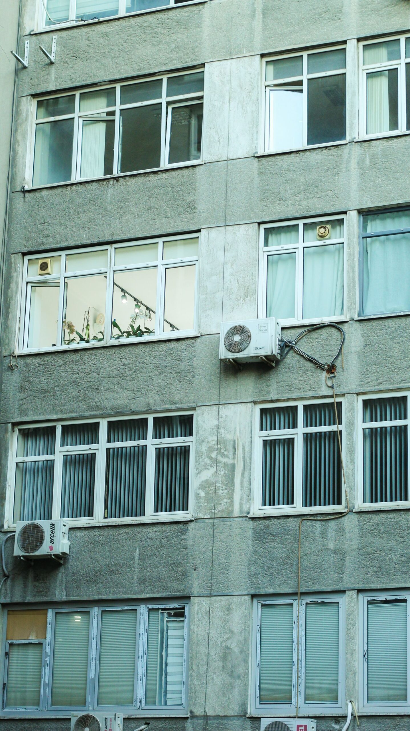 Unidad exterior de aire acondicionado colgada en la fachada de un edificio